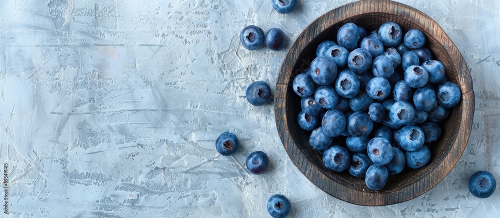 Aufkleber top view of a bowl filled with blueberries on a wooden surface against a white concrete background w