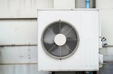 Close up an old air conditioner installed on the wall of a building.