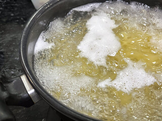 Pasta cooking in a pot of boiling water.