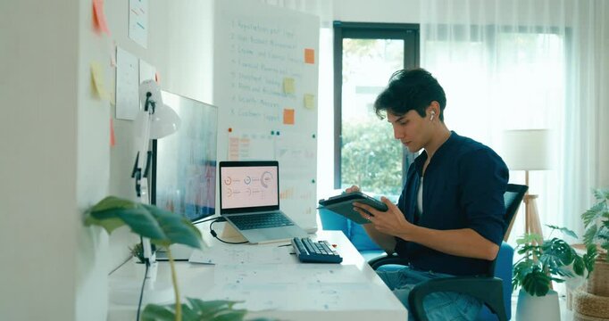 Young freelance Asia male use laptop talk to colleague plan in video call meeting on desk in living room at home office. Work from house, financial plan, remotely digital nomad job and Gen Z talent.