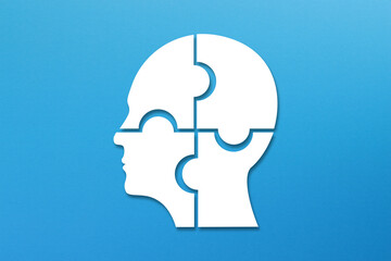 Head made of white jigsaw puzzle four pieces on blue background