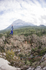 A tightrope walker walks along a rope stretched over a canyon.