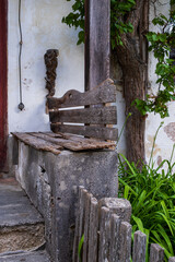 Old wooden bench in front of a house.