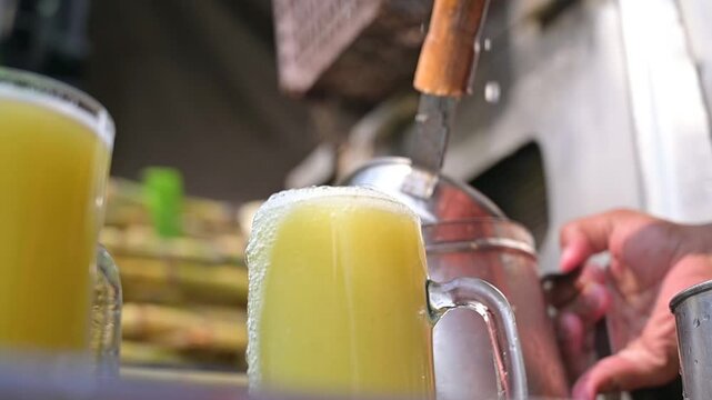 Vendor pouring sugar cane into glass, Man make eco sugarcane juice. Rural guy produce sweet rum drink. Street vendor chop up raw cane fiber. Local maker sell sugar sap. Grinder mill crush sugarcanes