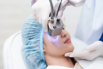 Side view of Asian woman getting resurfacing laser fraxel dual and ultrasound face treatment in...
