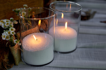 Bulk candle in a glass cylinder. Evening lighting. Romantic wedding decoration