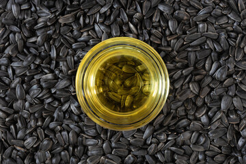 Background of sunflower seeds and vegetable oil in a glass bowl.