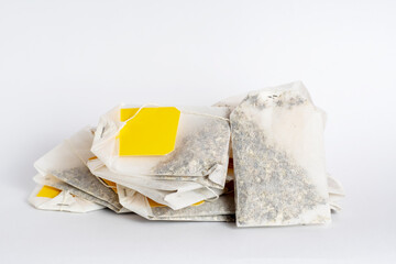 Several tea bags with empty labels on a white background. Template with blank tag on the theme of hot soft drinks.