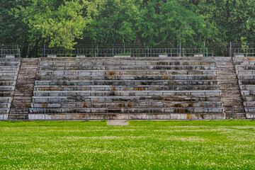 Obraz premium Empty stands of the old stadium. Concrete seats made from crumbling concrete in an abandoned sports stadium.