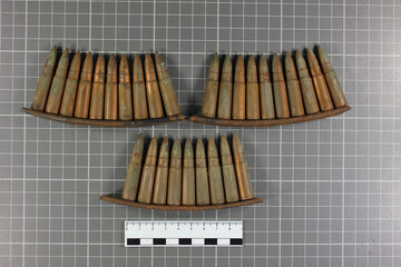 .32 caliber cartridges on a gray background with a ruler, forensic examination of weapons.