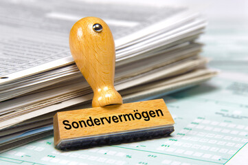 Ein Holzstempel ist beschriftet mit dem Aufdruck: Sondervermögen