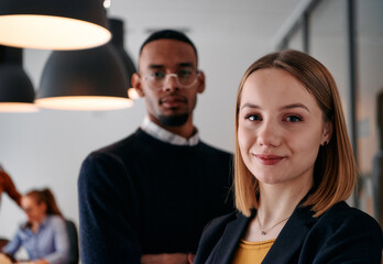 Dynamic Leadership Duo: Blonde Director and Young African American Entrepreneur in Office Setting.