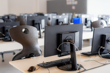 Monitors and keyboard in an empty computer lab at a secondary school.