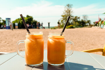 Summer mashed fruit jar cocktails on the table in the summer heat.