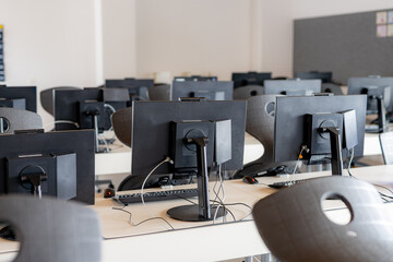 Monitors and keyboard in an empty computer lab at a secondary school.