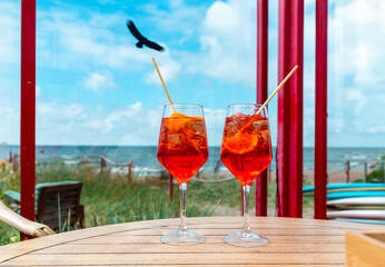 Couple Aperol Spritz Cocktail. Alcoholic beverage based on outdoor cafe table with ice cubes and...