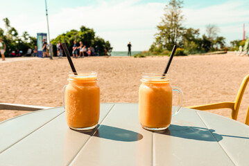 A couple of summer mashed fruit jar cocktails on the table in the summer heat.