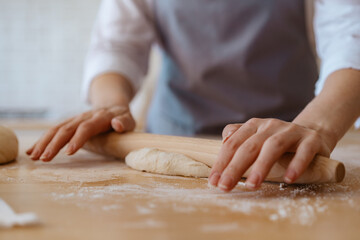 woman's hands kneading dough on the kitchen table

