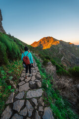 Obraz premium Hiking on the highest peak of Madeira Pico Ruivo next to the cottage Abrigo do Pico Ruivo. Views of the surrounding mountains lanscape during sunrise