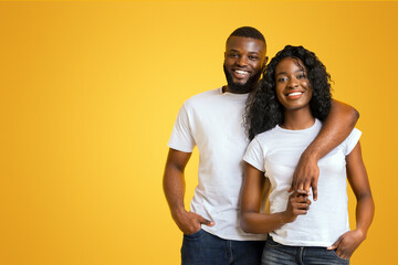 Young Afro Couple Cuddling, love is in the air, yellow background