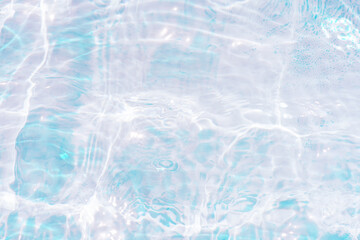 Blue water with ripples on the surface. Defocus blurred transparent blue colored clear calm water surface texture with splashes and bubbles. Water waves with shining pattern texture background.
