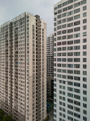 Massive hi rise residential building facades aerial view in vertical format. Details of housing development featuring several towers shot during the day.