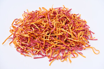 pile of colorful tagliolini pasta dyed with natural dyes on white background