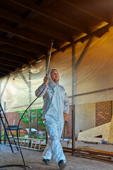 man paints a room with a spray gun