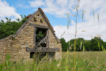 Old dilapidated and overgrown barn built of natural stone between Cornac and Saint-Céré Lot...