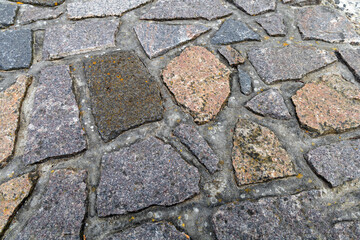 Background cobblestone road close-up. Stone pavement.