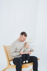 Young dad hugs his newborn son. Dad and little baby in hands. Happy dad with a child.