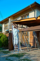 man paints a room with a spray gun