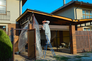 man paints a room with a spray gun