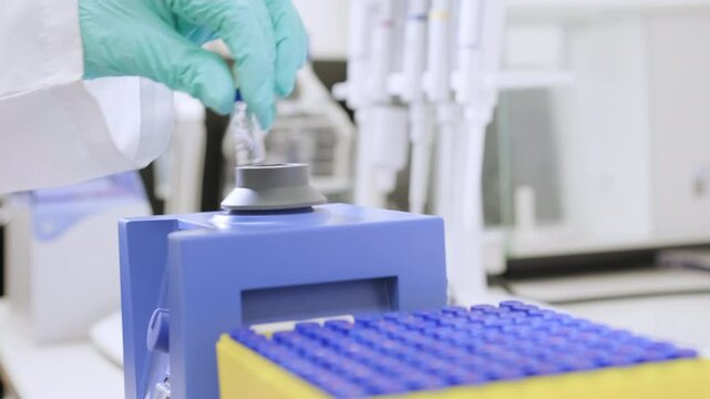 Close up of a woman shaking samples using a vortex mixer before HPLC analysis