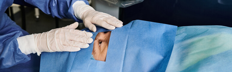Person in a blue suit and white gloves at a doctors office for laser vision correction. © LIGHTFIELD STUDIOS