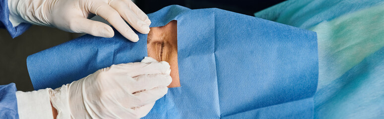 A person in white gloves meticulously performs surgery.