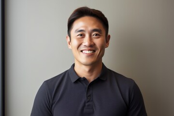 Fototapeta premium Portrait of a grinning asian man in his 30s wearing a breathable golf polo in modern minimalist interior