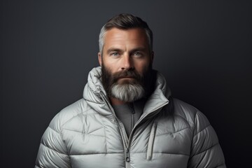 Obraz premium Portrait of a blissful man in his 40s donning a durable down jacket isolated on modern minimalist interior