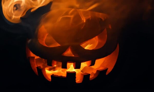 Halloween background with Evil Pumpkin. Smoke whirls dramatically, filling the frame before condensing back into a solid form. The smoke clears to reveal a evil halloween pumpkin.