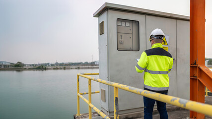 Electrical engineer man checking voltage at the Power Distribution Cabinet,preventive maintenance Yearly,Supervisor Working at a wastewater treatment plant