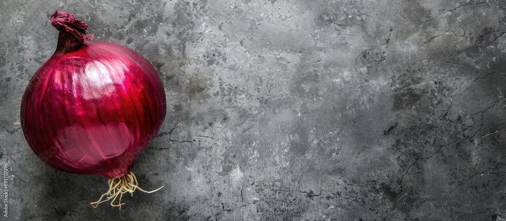 Poster top view of a red onion used for salads set against a grey backdrop with ample copy space image.
