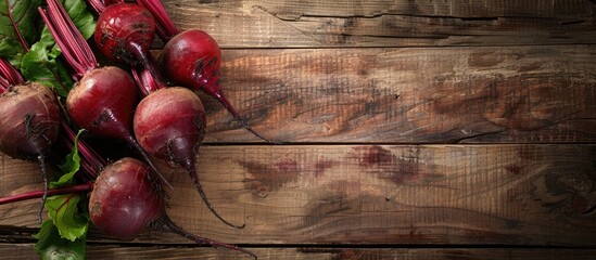 Red beetroots displayed on a rustic wooden surface with a blank area for additional elements in the frame, such as text or other images, known as copy space image.
