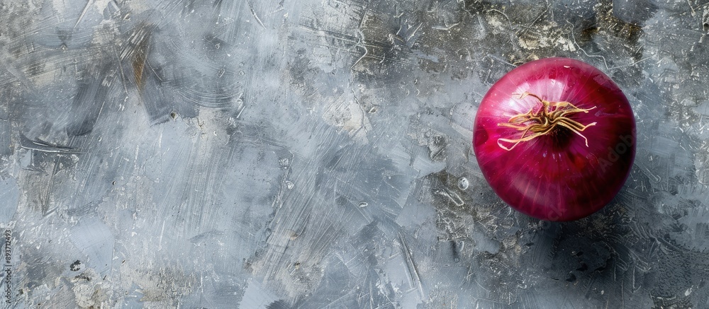 Poster top view of a red onion used for salads set against a grey backdrop with ample copy space image.