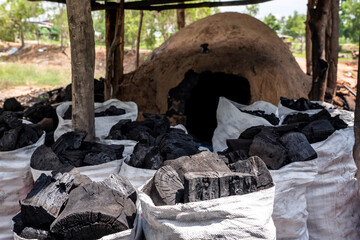 Charcoal in a sack from traditional production by processing of eucalyptus wood in charcoal making stove burning for one month util finish is products from the countryside of Thailand.