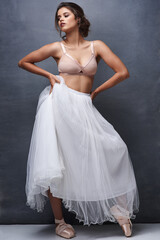 Fototapeta premium Calm woman, ballet dancer and relax with makeup, beauty or underwear for art, fashion or elegance on a wall background. Attractive female person, young model or performer in confidence, bra and skirt