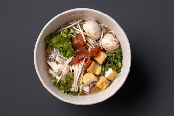 Asian tofu soup served in bowl on dark background. 
