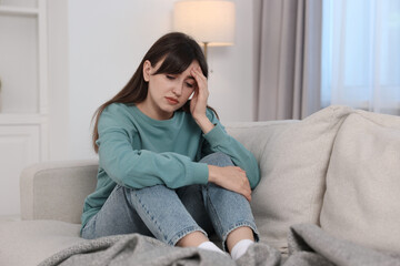 Obraz premium Loneliness concept. Sad woman sitting on sofa at home