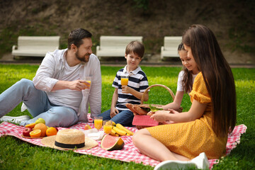 Happy family having picnic together in park