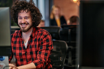 Focused Programmer With Afro Hairstyle in Plaid Shirt Working on Computer in Office Environment