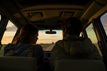 photo of two people sitting in a car made from the backseat